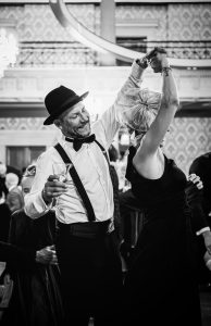 Foto van een outfit met bretels en hoed voor heren en mooie fascinator voor dames